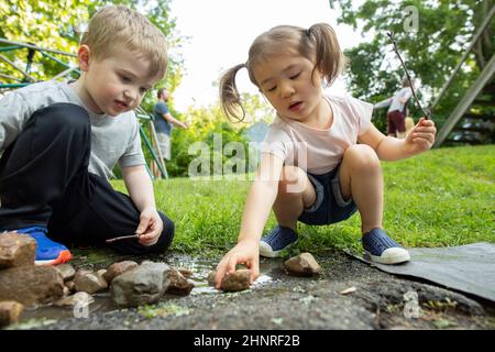 Kinder, die sich im Garten im Freien kreativ spielen Stockfoto