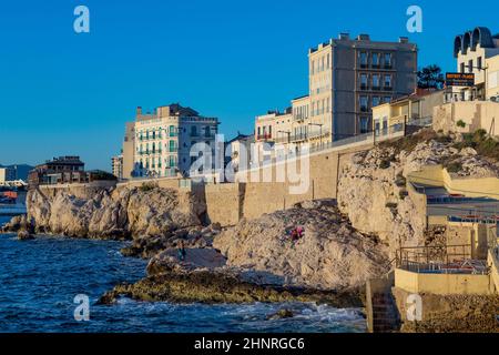 Die Menschen genießen den Sonnenuntergang an der Corniche Kennedy in Marseille Stockfoto