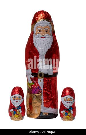 SchokoladenSanta isoliert. Nahaufnahme von drei fröhlich eingewickelten Schokoladen-Weihnachtsmann oder der guten Nikolaus-Figur auf weißem Hintergrund. Makrofotografie. Stockfoto