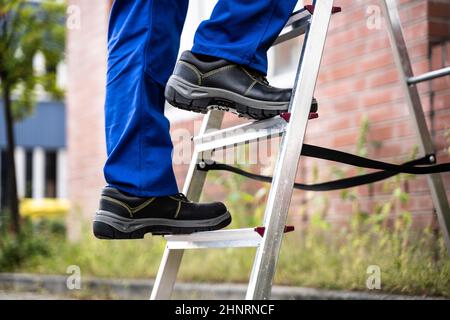 Mann Kletternde Trittleiter In Sicherheitsschuhen Stockfoto