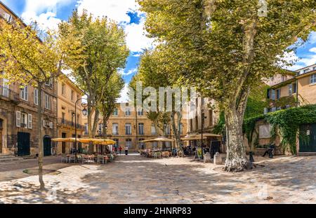 Die Menschen genießen es, sich an einem baumbestandenen Ort in der charmanten Altstadt von Aix en Provence auszuruhen Stockfoto