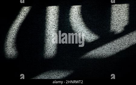 Abstraktes Design von Linien oder symbolförmigen Schatten auf Fensterblind von Sonne texturierten Hintergrund oder Hintergrund horizontalen Format in schwarz grau und weiß Stockfoto
