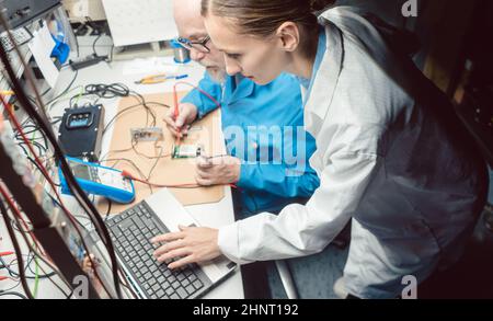 Team von Entwicklungsingenieuren, die im Labor neue elektronische Produkte entwickeln Stockfoto