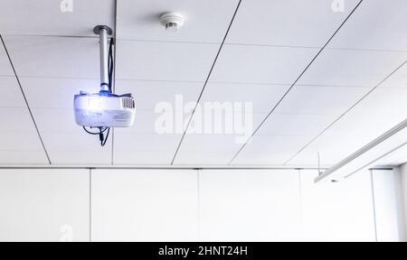 Ein weißer Overhead-Projektor an der Decke in einem Konferenzraum/modernen Klassenzimmer (farbiges Bild) Stockfoto