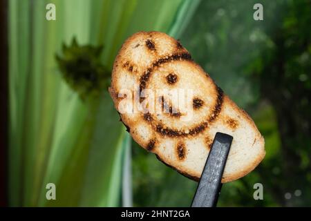 Geröstetes Brot mit lächelndem Sonnenbild. Symbol auf dem Toast Stockfoto