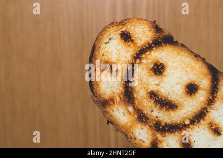 Geröstetes Brot mit lächelndem Sonnenbild. Symbol auf dem Toast Stockfoto