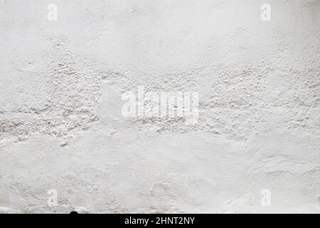 Nahaufnahme der Oberfläche einer weiß lackierten Wand mit Rauheit und Rissen. Leerer Hintergrund mit Kopierbereich Stockfoto