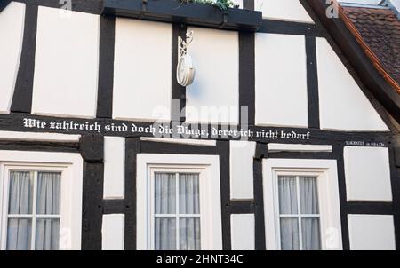 Fachwerkhaus mit Inschrift von Sokrates - was für viele Dinge brauche ich nicht Stockfoto