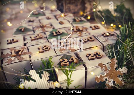 Selbstgemachtes weihnachtsadventkalender im Vintage-Stil. Liegende Würfel in Form eines weihnachtsbaums mit Lichterketten. Nahaufnahme mit kurzer Schärfentiefe. Stockfoto