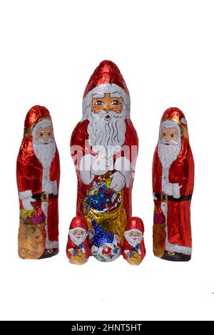 SchokoladenSanta isoliert. Nahaufnahme von fünf fröhlich eingewickelten Schokoladen-Weihnachtsmann oder der guten Nikolaus-Figur auf weißem Hintergrund. Makrofotografie. Stockfoto