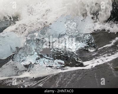 Während des Sonnenuntergangs funkeln unglaubliche Teile des Eisbergs am berühmten Diamond Beach in der Jokulsarlon Lagune Stockfoto