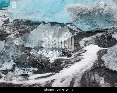 Während des Sonnenuntergangs funkeln unglaubliche Teile des Eisbergs am berühmten Diamond Beach in der Jokulsarlon Lagune Stockfoto