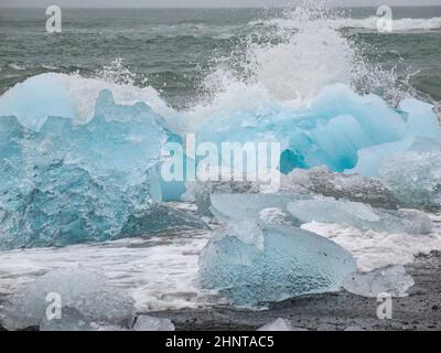 Während des Sonnenuntergangs funkeln unglaubliche Teile des Eisbergs am berühmten Diamond Beach in der Jokulsarlon Lagune Stockfoto