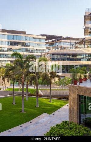 Modernes Stadtquartier mit Glasgebäuden, grünem Rasen und Bäumen Stockfoto