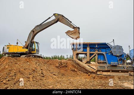 Der Bagger im Steinbruch gräbt Sand Stockfoto