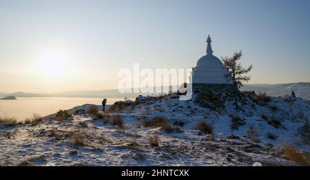 Tourist im Winter tragen fotografieren die buddhistische Stupa der Aufklärung im Winter auf der Insel Ogoy, Baikalsee, Russland Stockfoto
