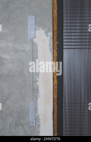 Eingangstür und Gegensprechanlage Telefonhörer an der Wand. Hörer hängen auf dem grauen Betonhintergrund aus der Nähe Stockfoto