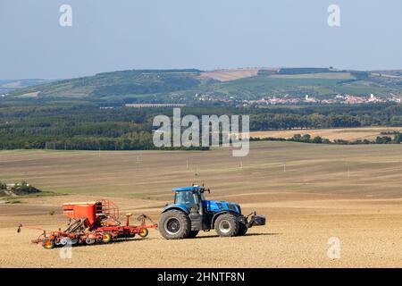 Traktor mit Saatbohrer in der frühen Frühlingslandschaft Stockfoto