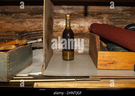 Alte Glasflasche mit technischer Flüssigkeit in einer Werkstatt Stockfoto