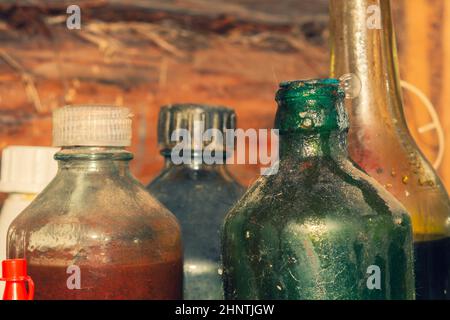 Alte Glasflaschen mit technischen Flüssigkeiten in einer Werkstatt Stockfoto