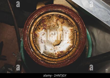 Rostiger Farbbecher, alter Eimer mit Acrylfarbe in einer Werkstatt Stockfoto
