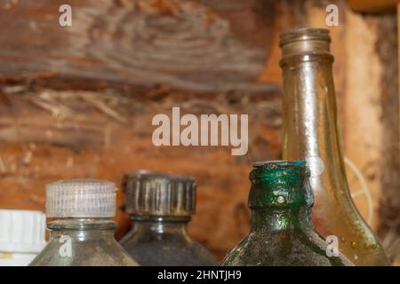 Alte Glasflaschen mit technischen Flüssigkeiten in einer Werkstatt Stockfoto