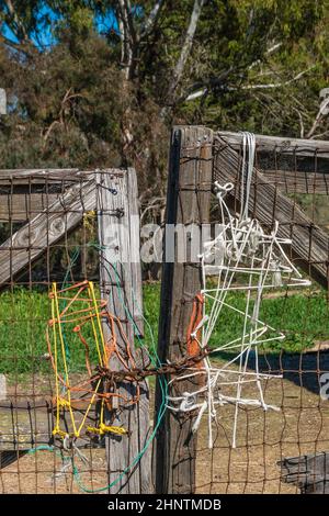 Ein Ansatz von Rube Goldberg zur Sicherung eines Landzauntors. Mit anderen Worten, ein Designansatz, der ihn unnötig kompliziert macht. Stockfoto