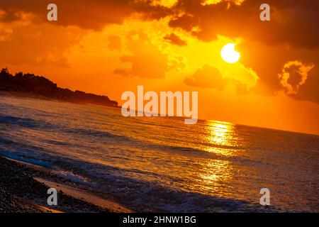 Goldene Farben des schönsten Sonnenuntergangs am Strand von Ialysos auf der griechischen Insel Rhodos. Stockfoto