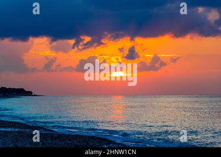 Goldene Farben des schönsten Sonnenuntergangs am Strand von Ialysos auf der griechischen Insel Rhodos. Stockfoto