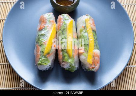 Ein Teil von Nem Cuon, vietnamesische frische Frühlingsrollen aus nächster Nähe auf einem graublauen Teller Stockfoto
