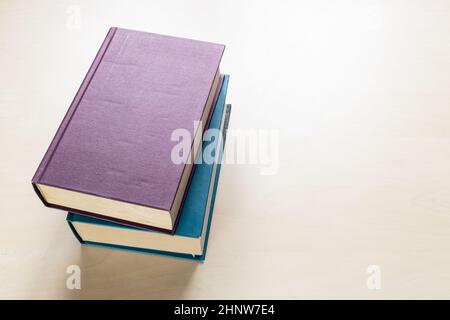 Draufsicht auf zwei dicke Bücher auf hellbraunem Holzbrett Stockfoto