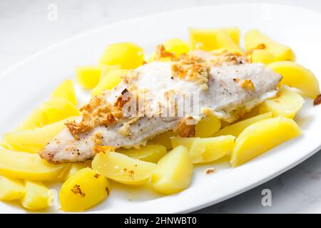 zander auf Knoblauch serviert mit gekochten Kartoffeln Stockfoto