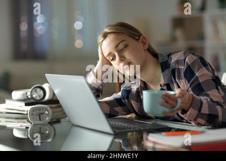 Schlafende müde Student versucht, zu Hause in der Nacht Kaffee trinken zu lernen Stockfoto