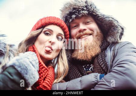 Paar in verdorrter Kleidung, die Frau streckte ihre Zunge an die Kamera Stockfoto