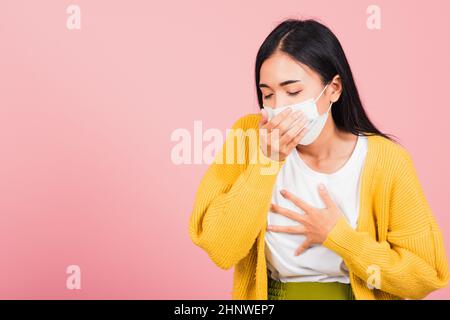 Asiatische schöne junge Frau trägt medizinische Maske Schutz zur Infektion Coronavirus verhindern, COVID-19 Sie husten niesen, Studio Schuss isoliert auf rosa Stockfoto