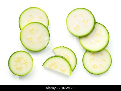 Stücke von Zucchini in Scheiben geschnitten isoliert auf weißem Hintergrund. Flach liegend, Draufsicht Stockfoto