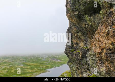 Blick hinter den Felsklippen am Fluss Hydna auf dem Berg Veslehødn Veslehorn in Hemsedal, Norwegen. Stockfoto