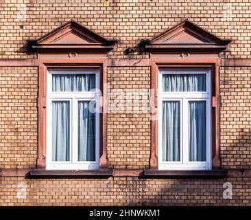 Fassade des klassizistischen Hauses mit Backsteinmauer und modernen Fenstern Stockfoto