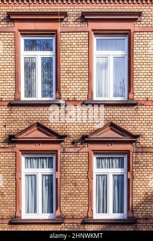 Fassade des klassizistischen Hauses mit Backsteinmauer und modernen Fenstern Stockfoto