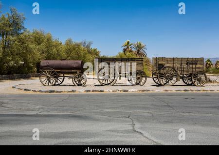 Alter Wagen am Eingang der Furnance Creek Ranch mitten im Death Valley, mit diesen Wagen überquerten die ersten Männer das Death Valley im Stockfoto