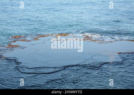 Meereswellen krachen mit weißem Schaum auf den Felsen. Schaumig schaumiges Meerwasser über dem Felsen in der Nähe von Akko (Akko) Israel Stockfoto