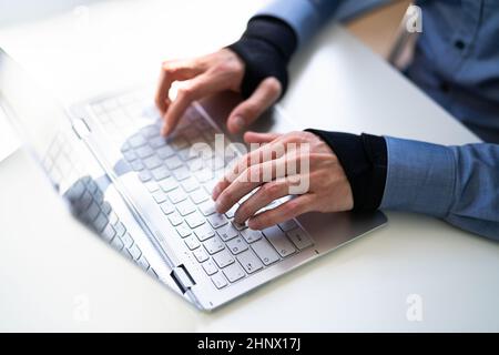 Pain Relief Bandage Und Handgelenkschlaufe. Tippen Auf Der Tastatur Stockfoto