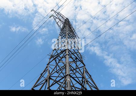 Elektrizitätskonzept, Nahaufnahme Hochspannungsfreileitungen Station. Hochspannungs-Strommast mit elektrischer Übertragung, Silhouetted Tower. Blauer Himmel und niedriger Winkel wetteifern Stockfoto