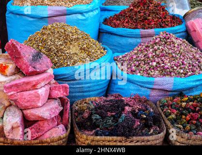 Stapel getrockneter Rosen und anderer Blumen, die als natürliche Düfte verwendet werden, werden auf dem Souk - dem traditionellen Straßenmarkt in Marokko - präsentiert. Stockfoto