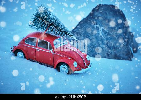 Kostanay, Kasachstan 2022. Roter Volkswagen-Käfer bei schneebedecktem Wetter mit Fichte auf dem Dach, im Schnee stecken geblieben Stockfoto