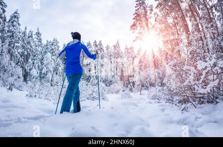 Skifahrer fuss auf Skiern im verschneiten Winterwald. Konzept von Urlaub und Wochenende. Stockfoto