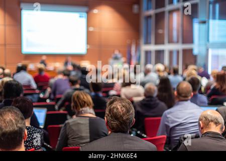 Business &amp; Entrepreneurship Symposium. Lautsprecher, einen Vortrag bei Geschäftstreffen. Publikum im Konferenzsaal. Rückansicht des unbekannten Teilnehmern Stockfoto