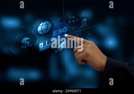 Investitionen in Umwelt, Soziales und Governance (Environmental, Social, and Governance) Organisationswachstum. Die Hand des Geschäftsmanns berührt auf einem virtuellen Bildschirm das Symbol für das Wort „es)“. Stockfoto