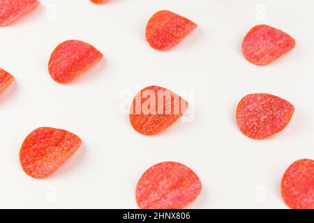 Tortilla-Chips-Muster auf rotem Hintergrund. Wiederholungskonzept. Draufsicht Stockfoto