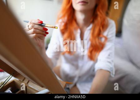 Die Künstlerin sitzt zu Hause vor einer Staffelei Stockfoto
